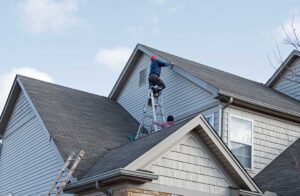 Homeowner sorts shingles, metal flashing, and roofing paper into separate covered containers.
